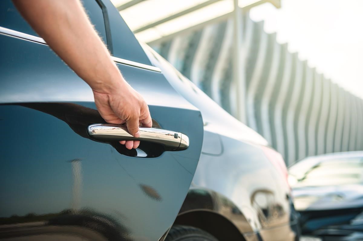 Homme ouvrant une porte de voiture