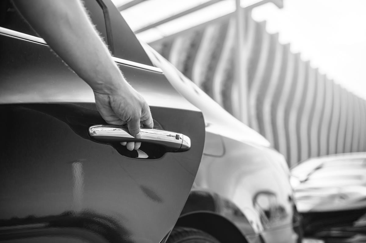 Homme ouvrant la porte arrière d'une voiture
