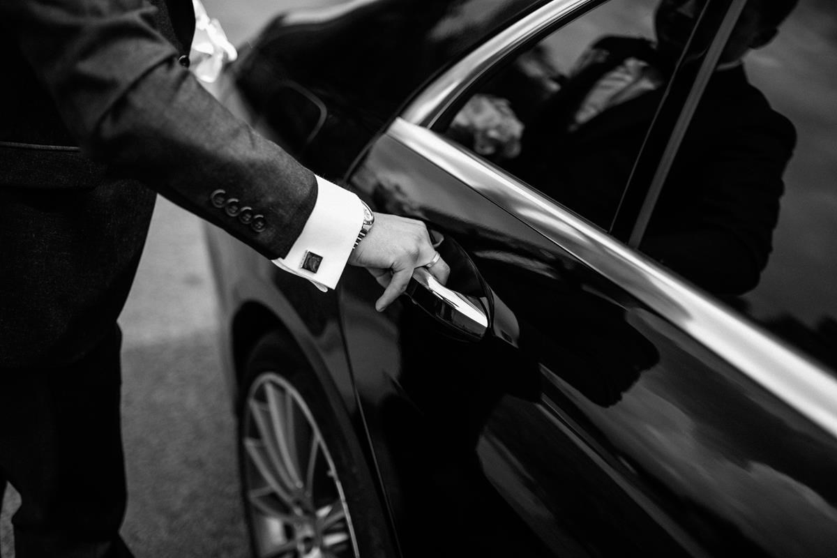 Chauffeur qui ouvre la porte de la voiture